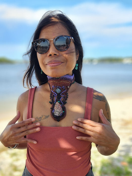 Poppy Jasper Pendant worn by a woman at the beach, showcasing ornate micromacramé tribal choker design.