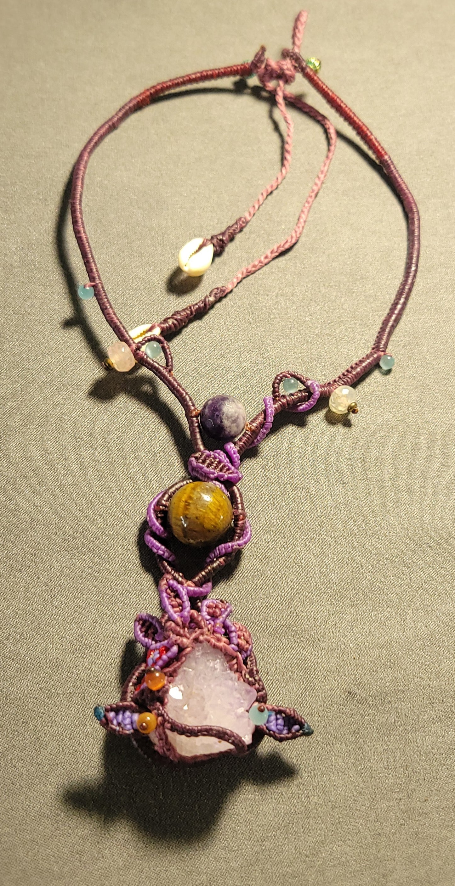 Amethyst Crystal Necklace with raw amethyst pendant, tiger eye stone accents, and macramé design