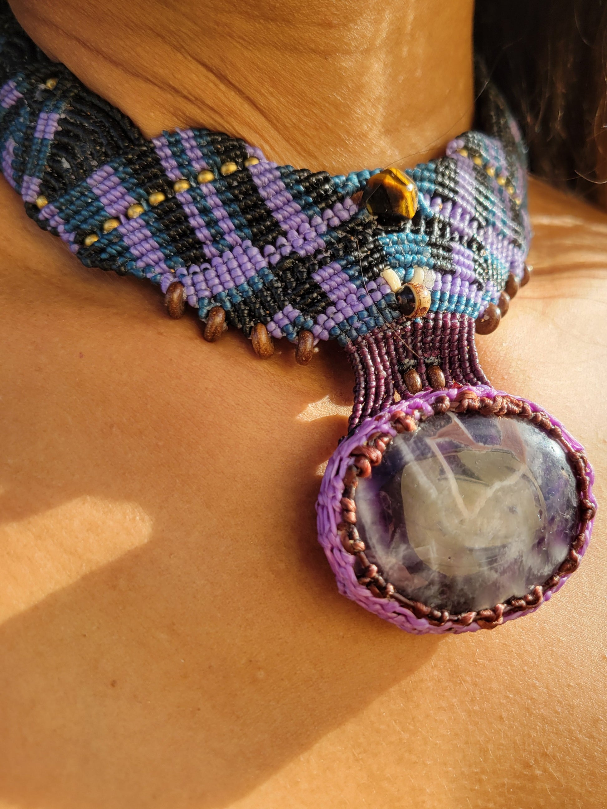 Amethyst Crystal Pendant showcased on a wide geometric micromacramé choker, featuring natural amethyst crystal in purple tones.