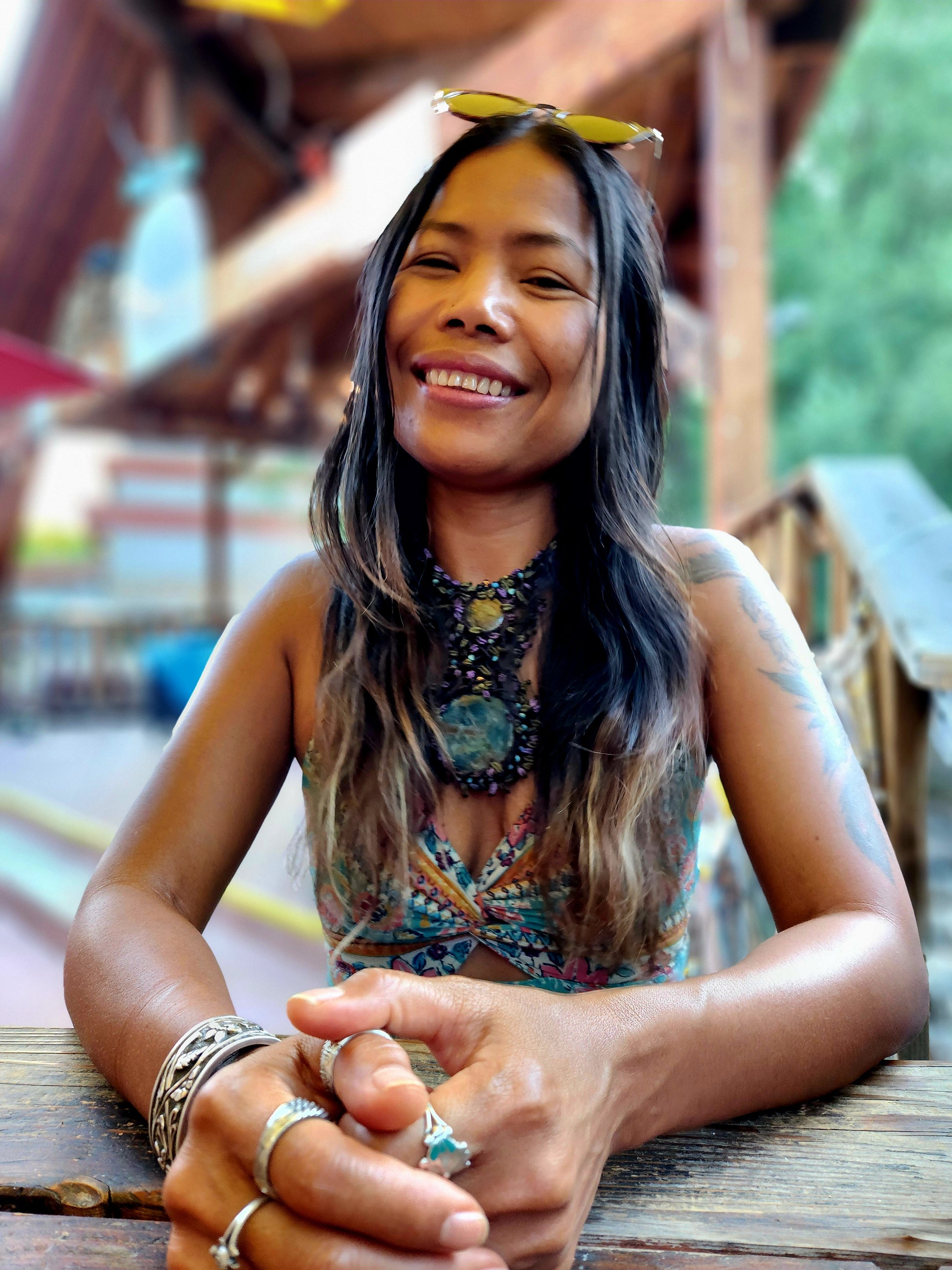 Labradorite Pendant Necklace worn by a smiling woman with long hair outdoors, showcasing vibrant colors and intricate design.