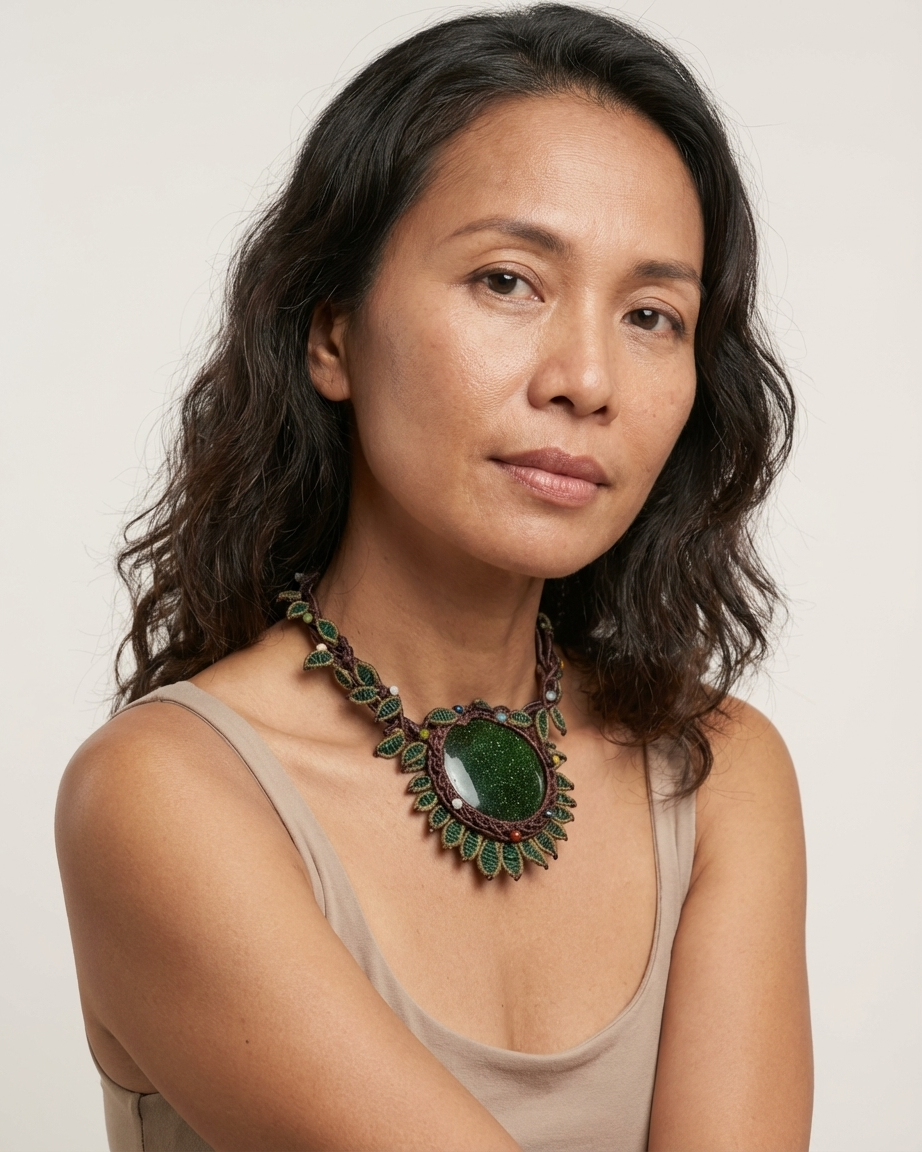 Sandstone Necklace worn by a woman, featuring dark green sandstone and micromacramé flower design.