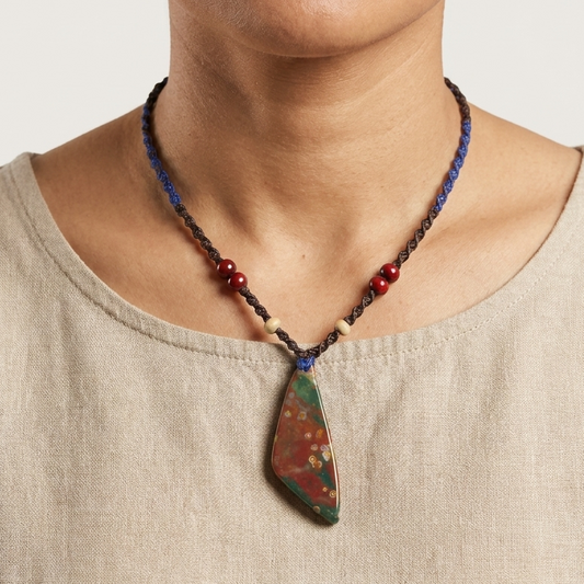 Bloodstone Pendant – The Watcher Stone on a simple macramé necklace, showcasing its unique dark red patterns and minimalist design.