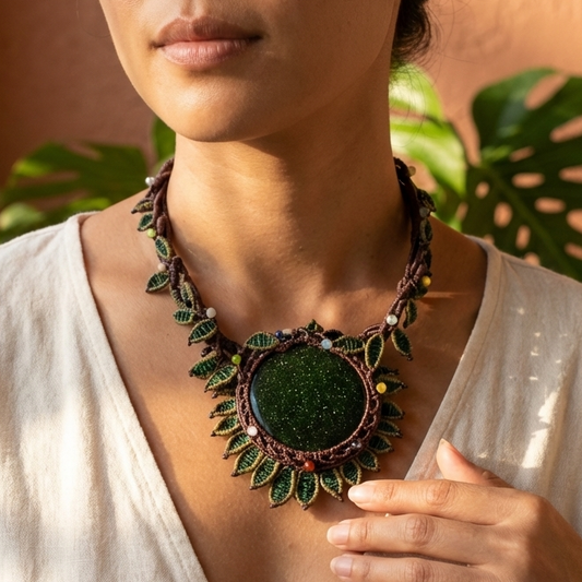 Sandstone Necklace worn by a model, featuring a large dark green sandstone stone and micromacramé flower petal design.