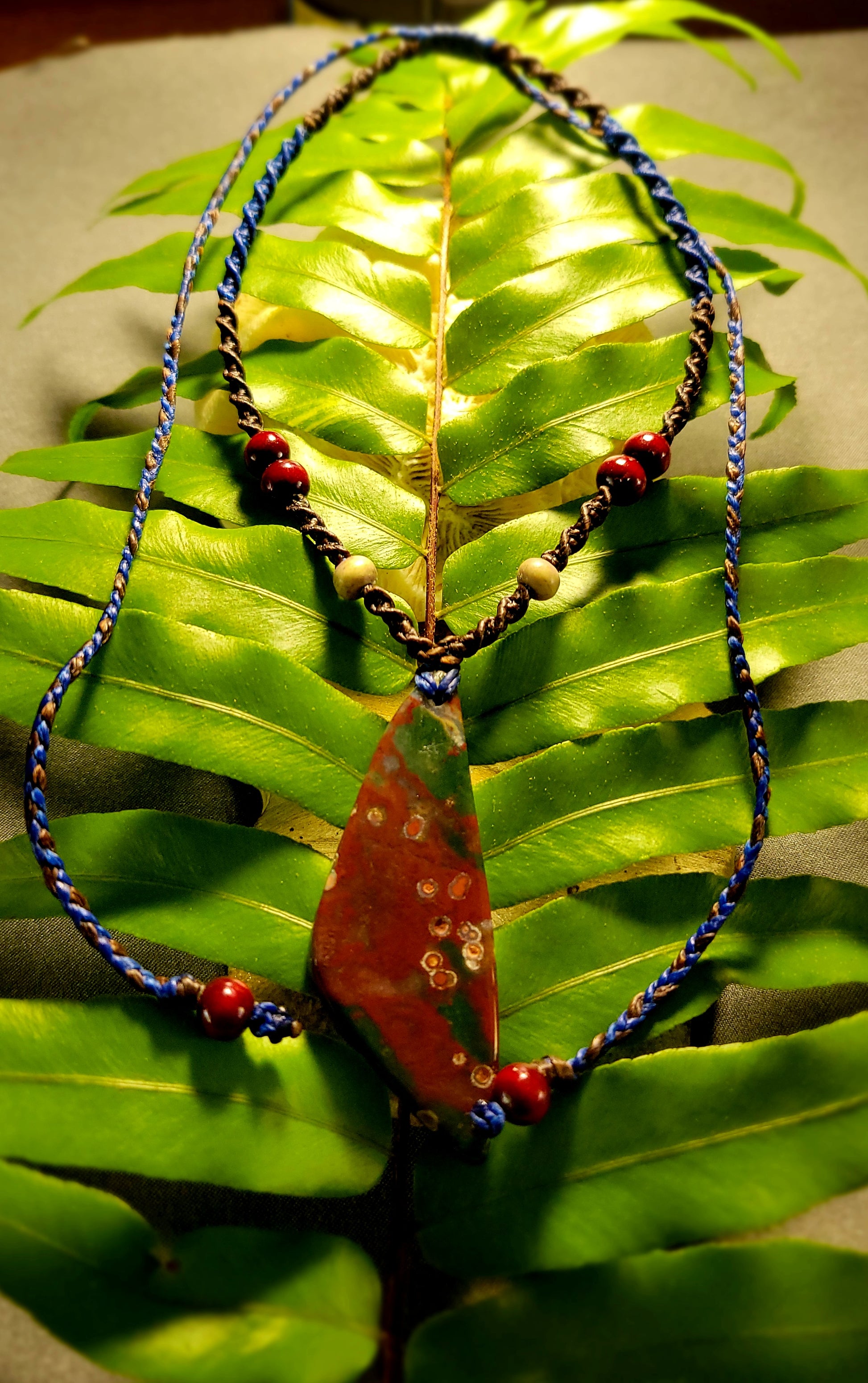 Bloodstone Pendant – The Watcher Stone featuring natural dark red bloodstone on a spiral-braided macramé necklace.