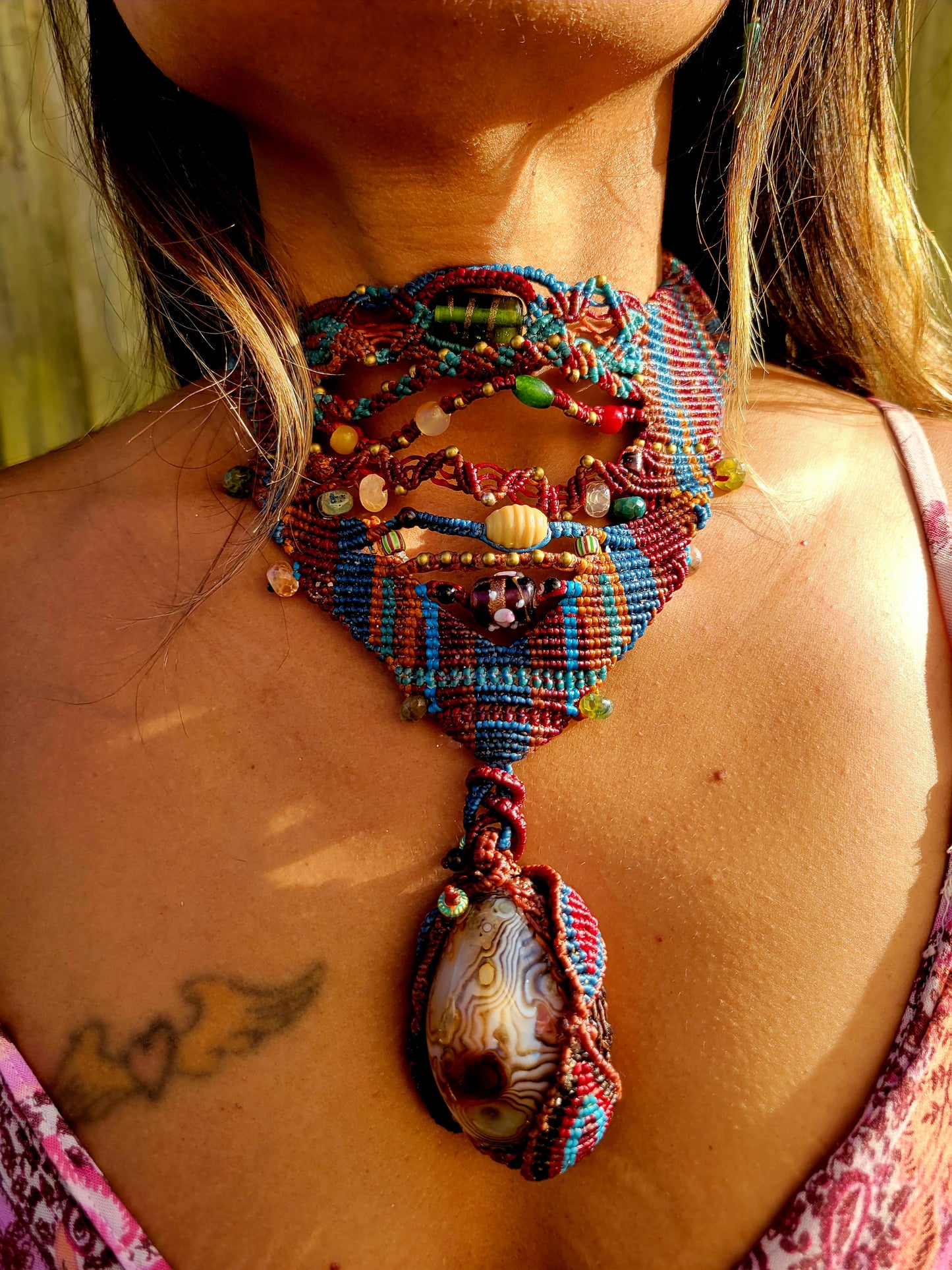 Botswana Agate Pendant shown on a model, featuring intricate micromacramé and natural stone beads in earthy tones.