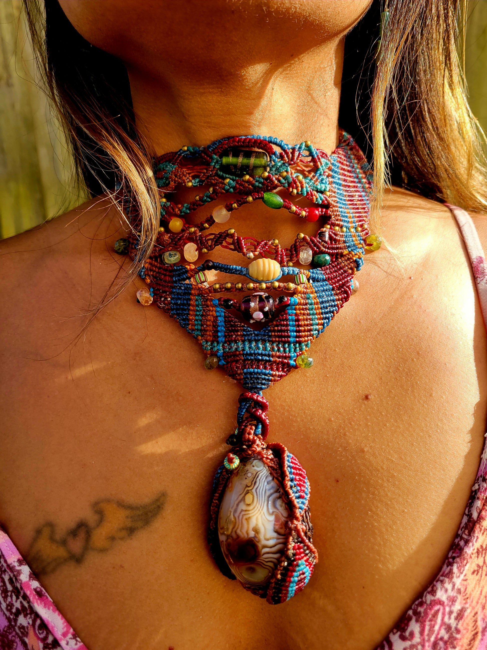 Botswana Agate Pendant shown on a model, featuring intricate micromacramé and natural stone beads in earthy tones.
