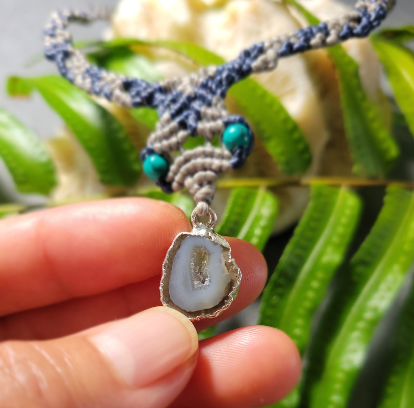 Agate Geode Necklace – Natural slice with malachite accents held in hand, showcasing pendant and handmade design.