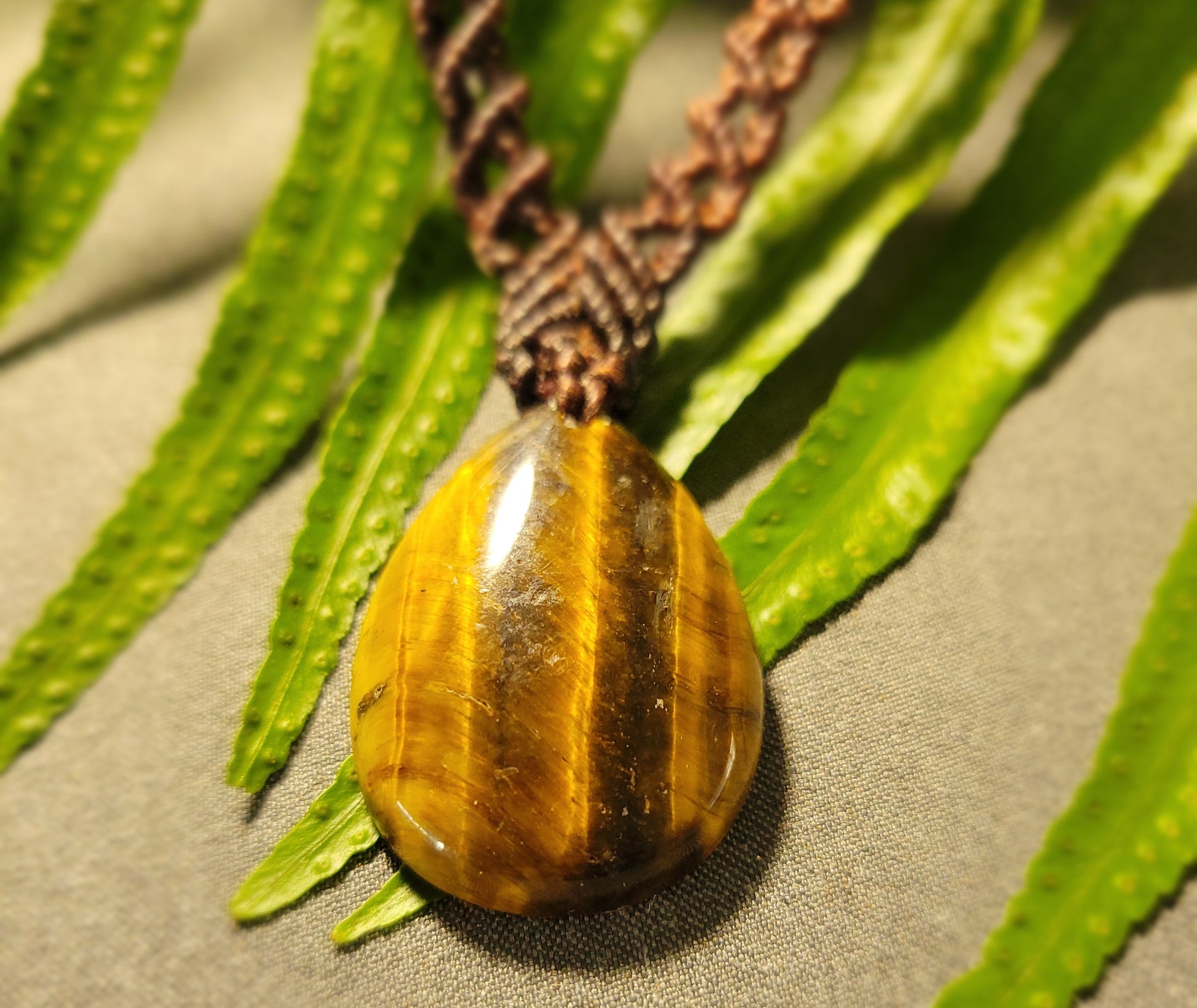Tiger Eye Necklace – Double Helix Boho Luxe Pendant featuring a natural banded tiger eye stone and braided dark brown necklace.