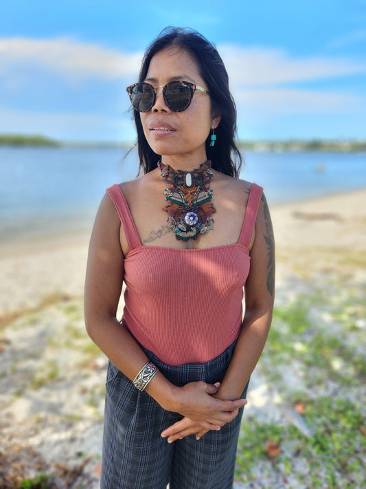 Woman wearing Boho Luxe Choker by the beach, featuring intricate micromacramé and floral glass bead pendant.