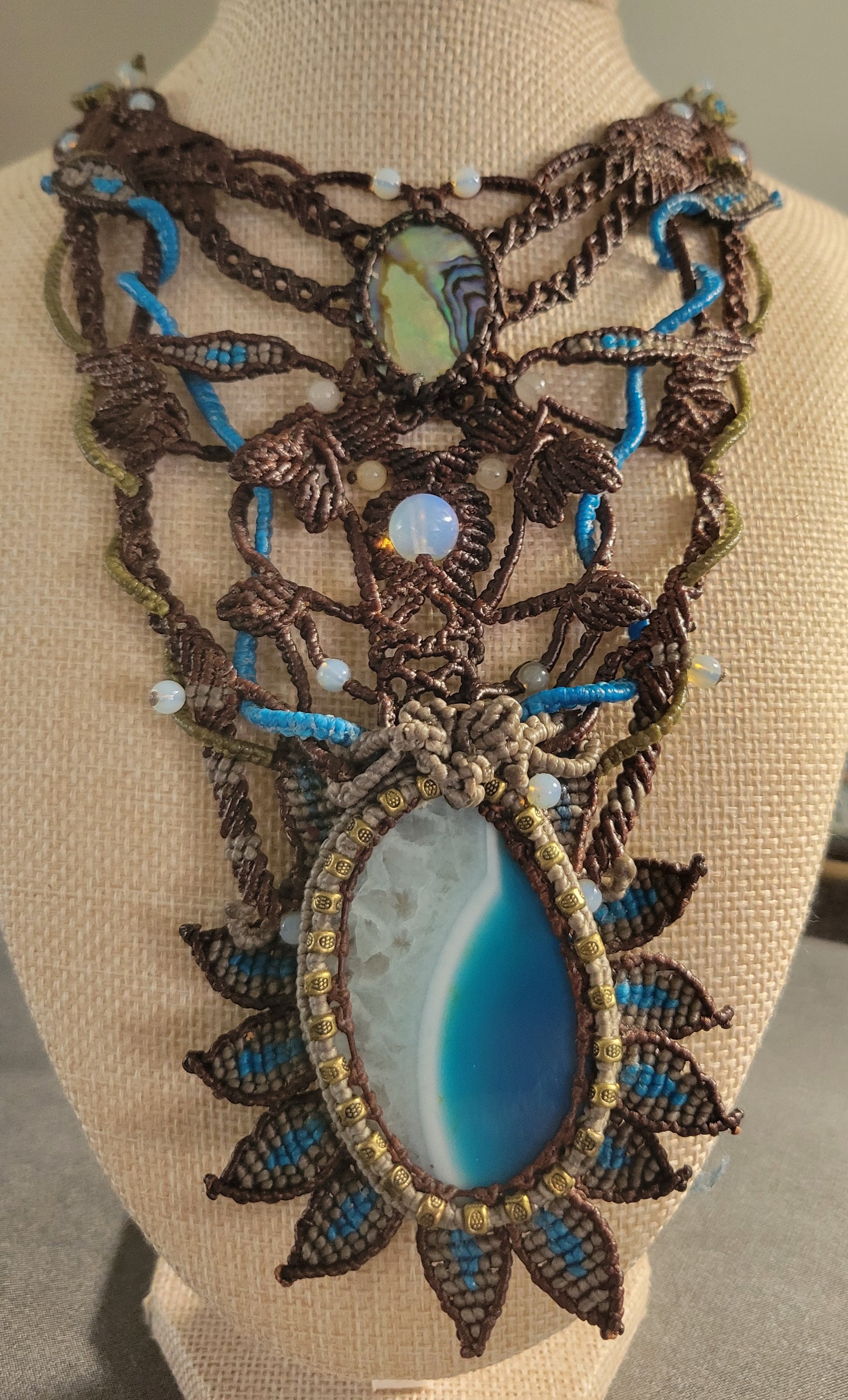 Agate Boho Necklace featuring a deep blue agate pendant and ornate micromacramé design with ocean wave elements.