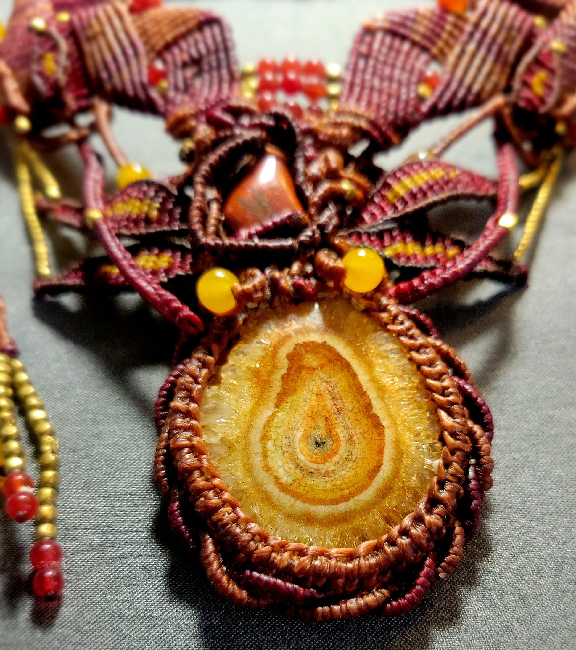 Agate Boho Necklace featuring honey yellow agate stalactite slice and red carnelian beads in a macramé design.