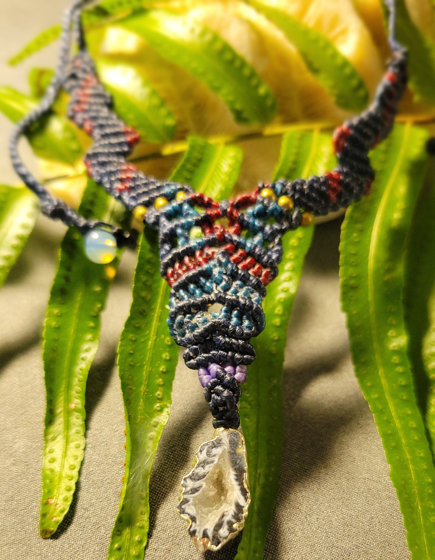 Agate Pendant Necklace featuring a Y-shaped macramé design and natural agate geode on a colorful cord.