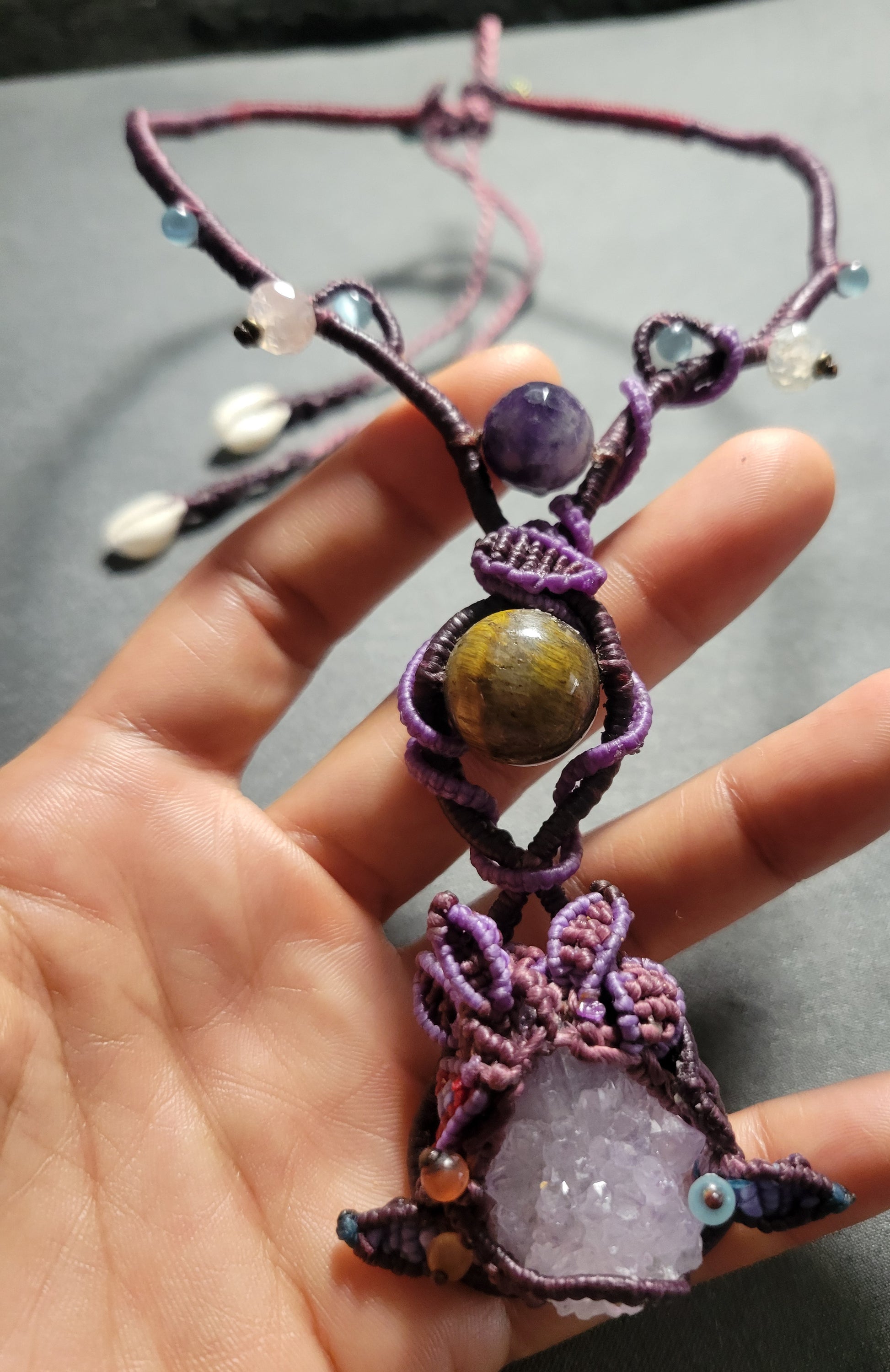 Amethyst Crystal Necklace featuring large raw amethyst, tiger eye stone, and intricate macramé design.