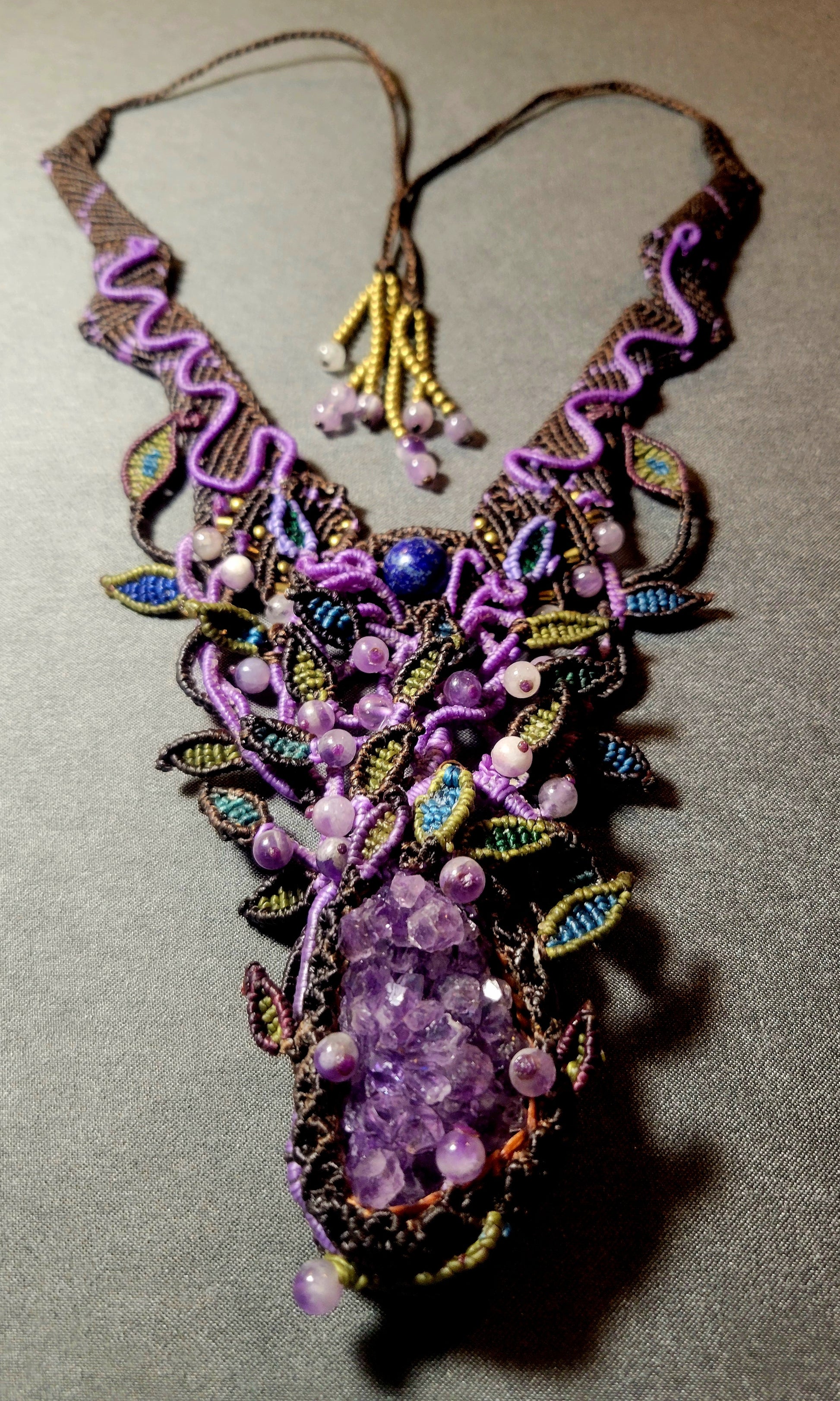 Amethyst Pendant featuring a large raw amethyst crystal in an intricate micromacramé choker design with colorful accents.