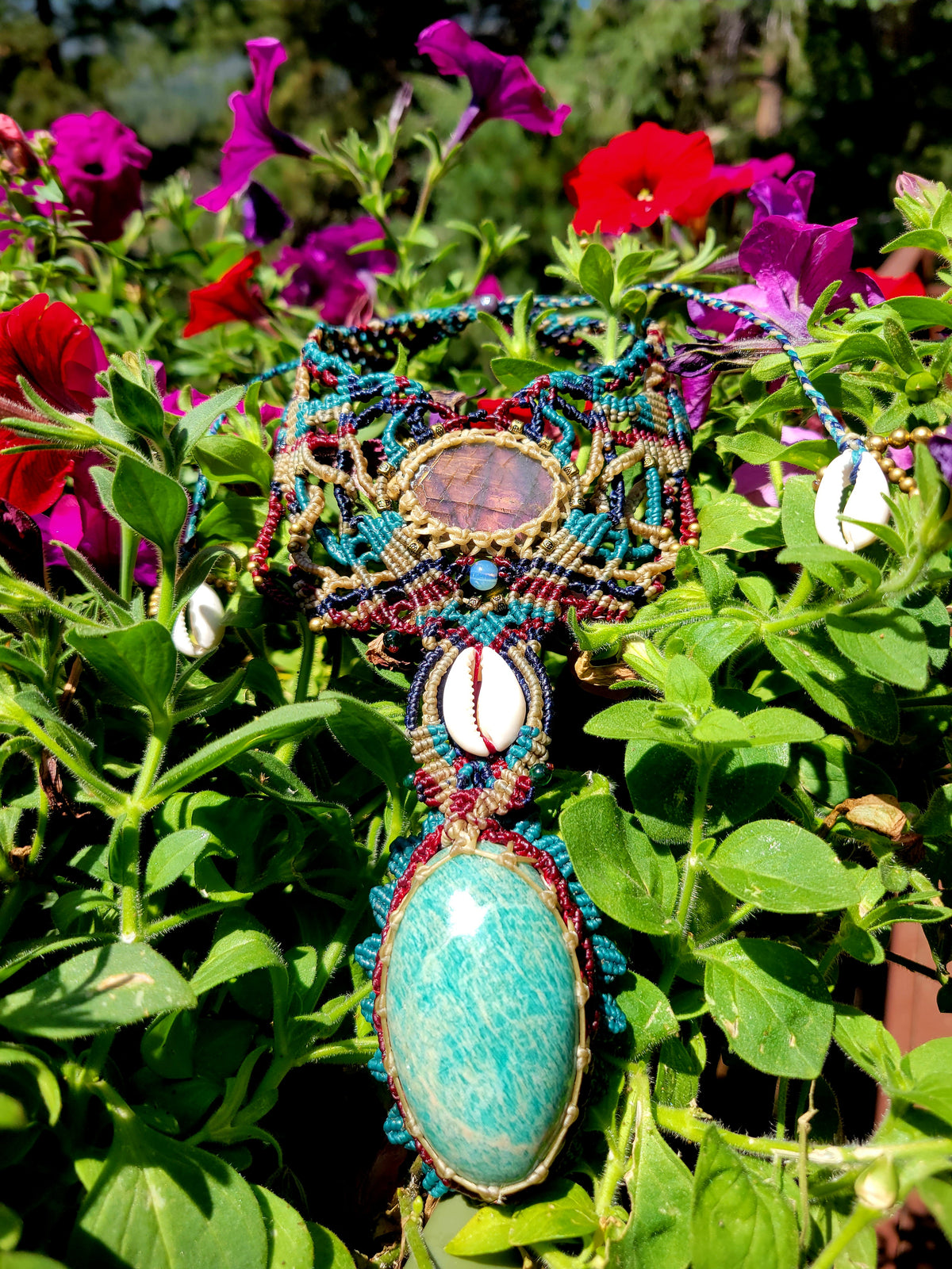 Amazonite Pendant Necklace featuring a large amazonite gemstone and intricate micromacramé design among vibrant flowers.