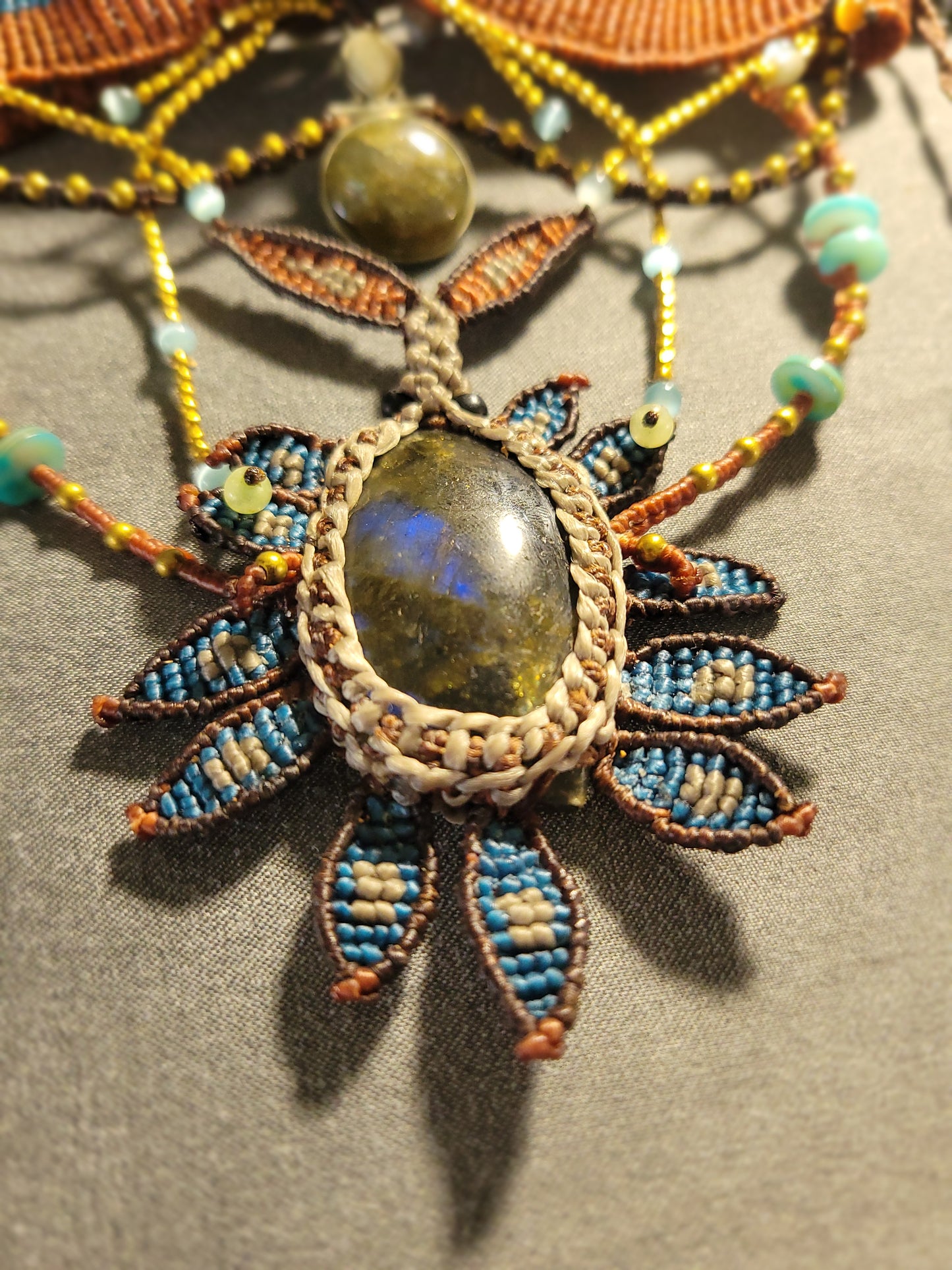 Labradorite Necklace featuring a large iridescent stone with intricate micromacramé and sunflower petal design.