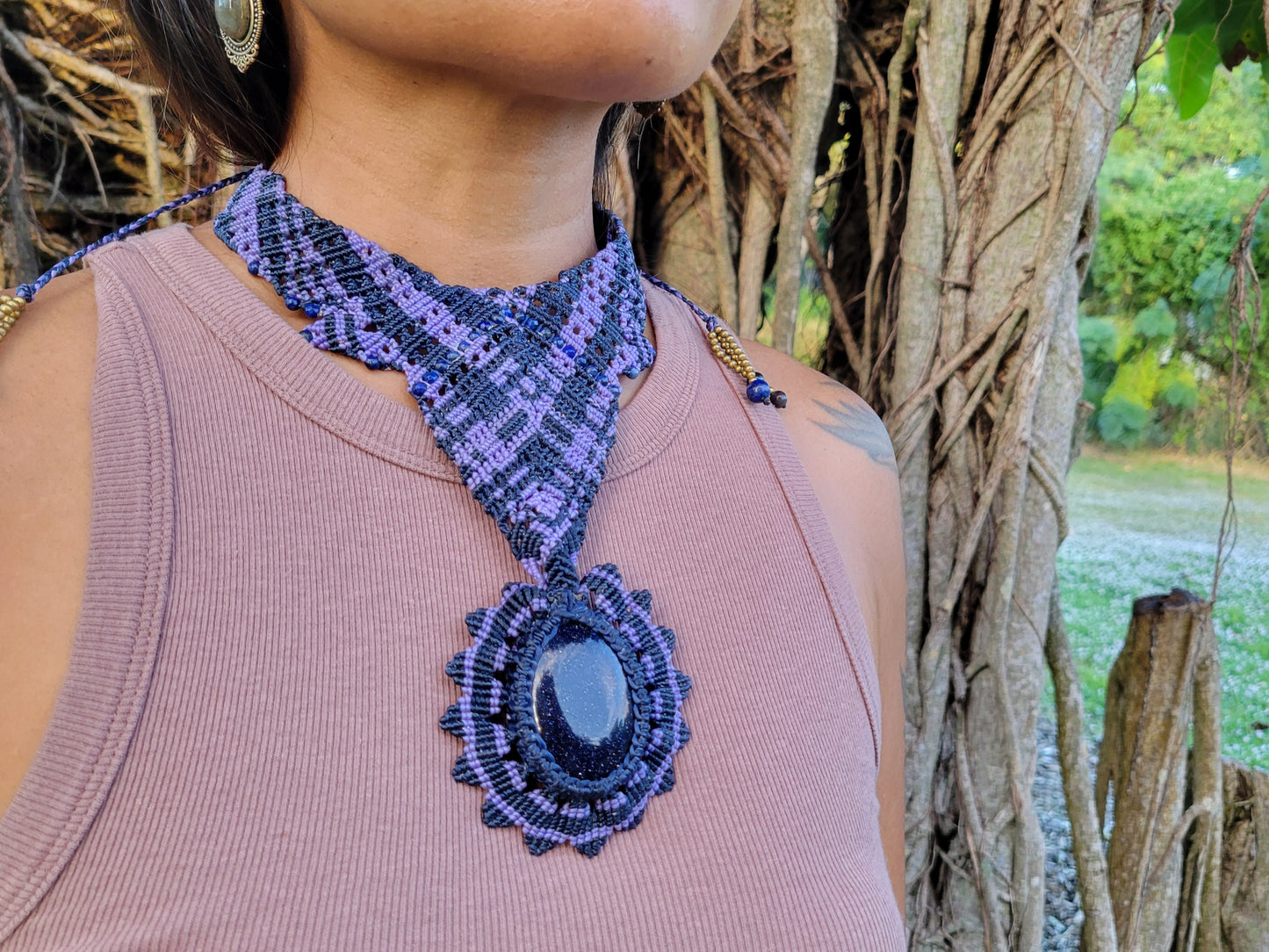 Handmade Boho Necklace featuring a blue sandstone cabochon and intricate macramé knotwork in purple tones.