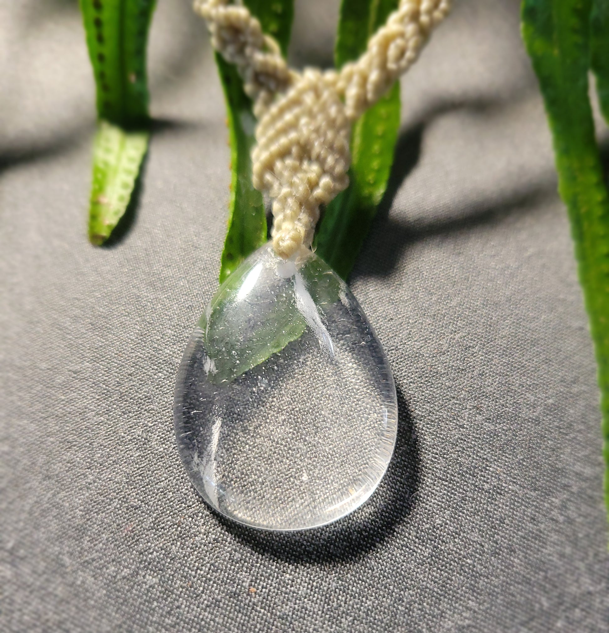 Quartz Necklace featuring a drop-shaped natural clear quartz pendant on light brown macramé cord.
