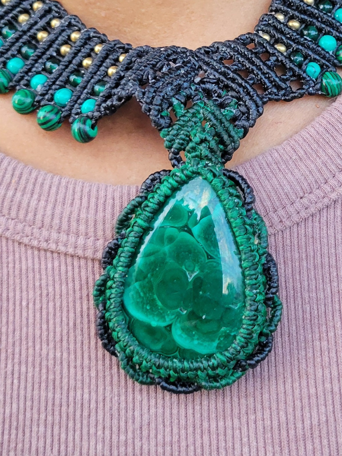 Malachite Pendant Necklace featuring large natural malachite stone on a brown macramé choker with green beads.