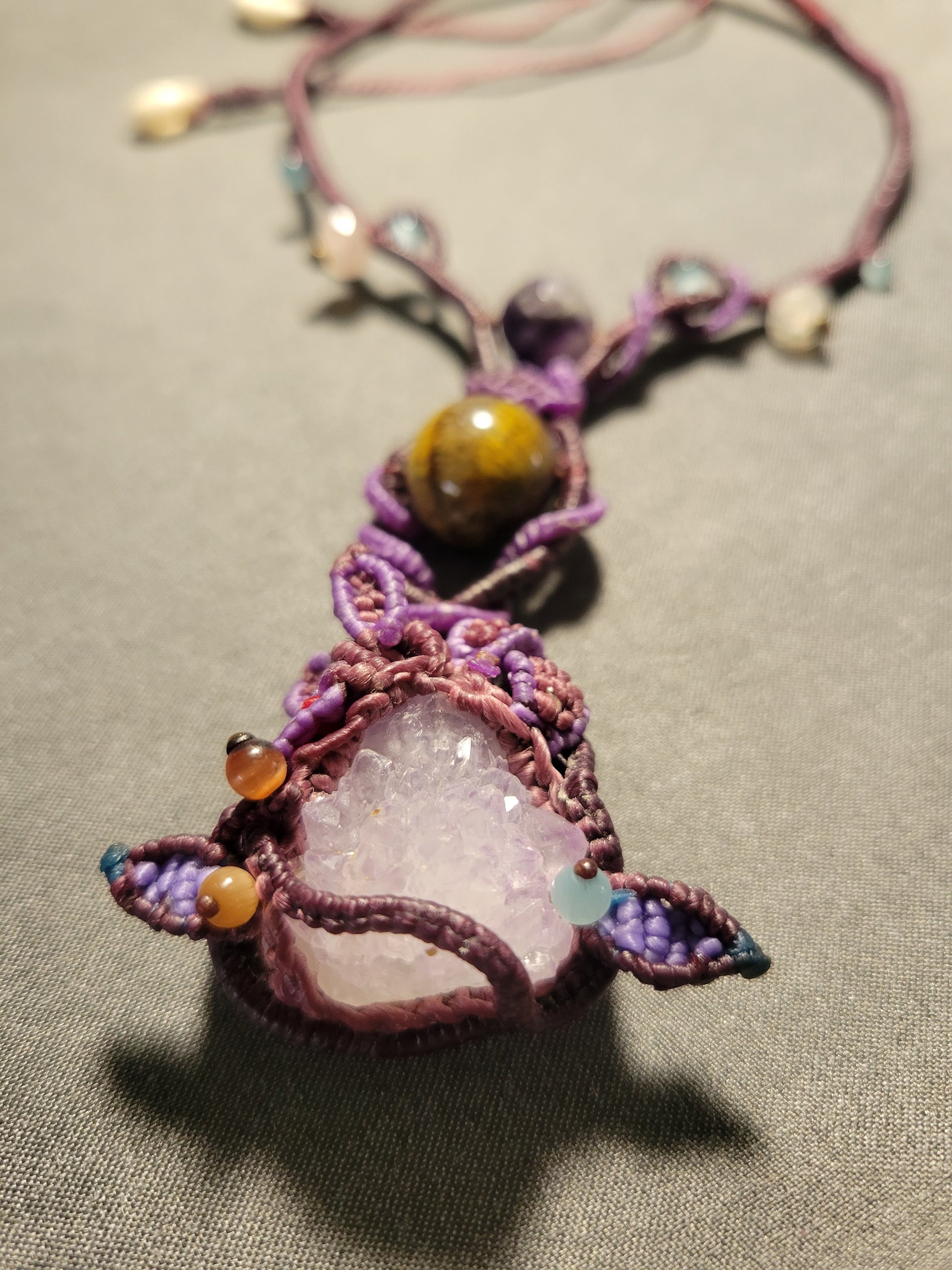 Amethyst Crystal Necklace – Dancing Energy Talisman featuring a raw amethyst pendant and tiger eye stone details