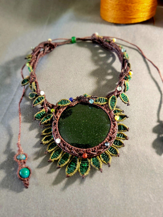 Sandstone Necklace featuring a dark green sandstone centerpiece with micromacramé flower petal design and leaf accents.