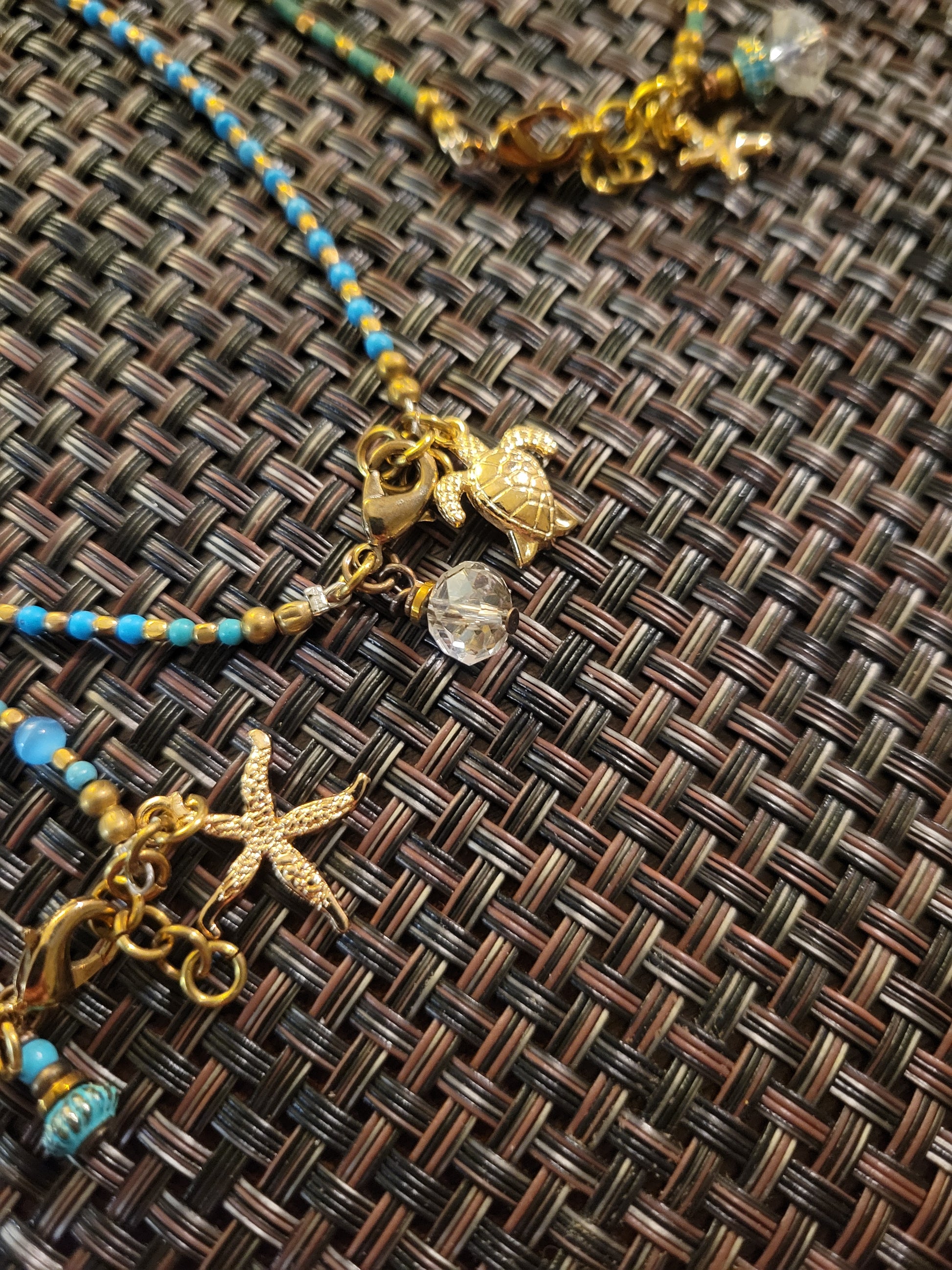 Boho Anklets featuring beaded design with ocean charms including sea star and turtle on a woven background.