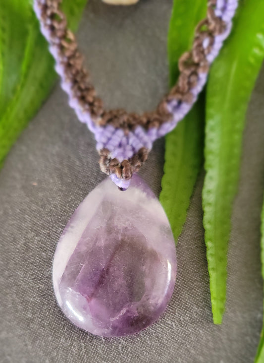Amethyst Pendant – 'Purple Rain' Teardrop Crystal Pendant Necklace with macramé chain on greenery background.