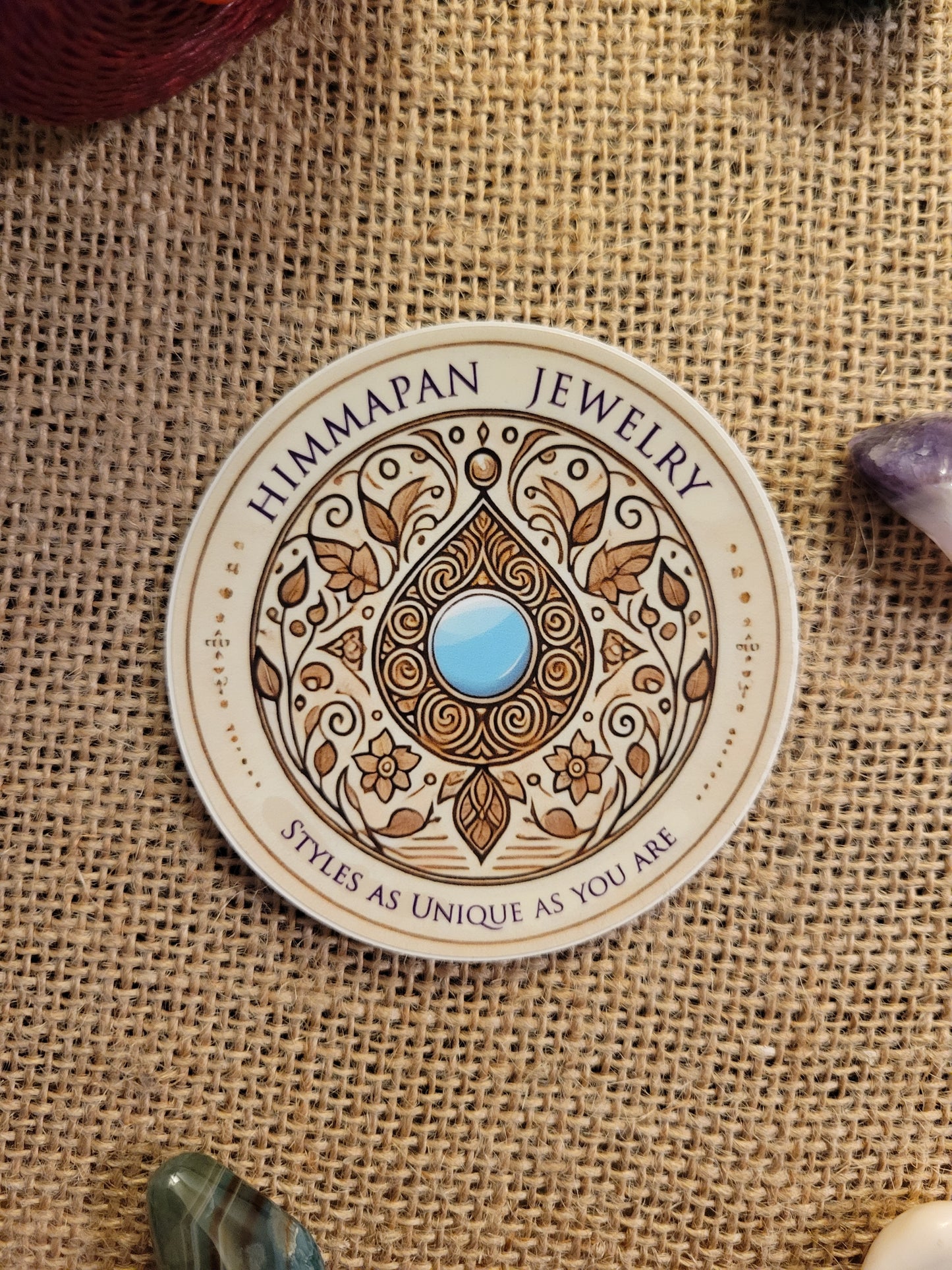 Himmapan Jewelry Logo Sticker – 3-inch round waterproof vinyl decal with floral design and blue gem.