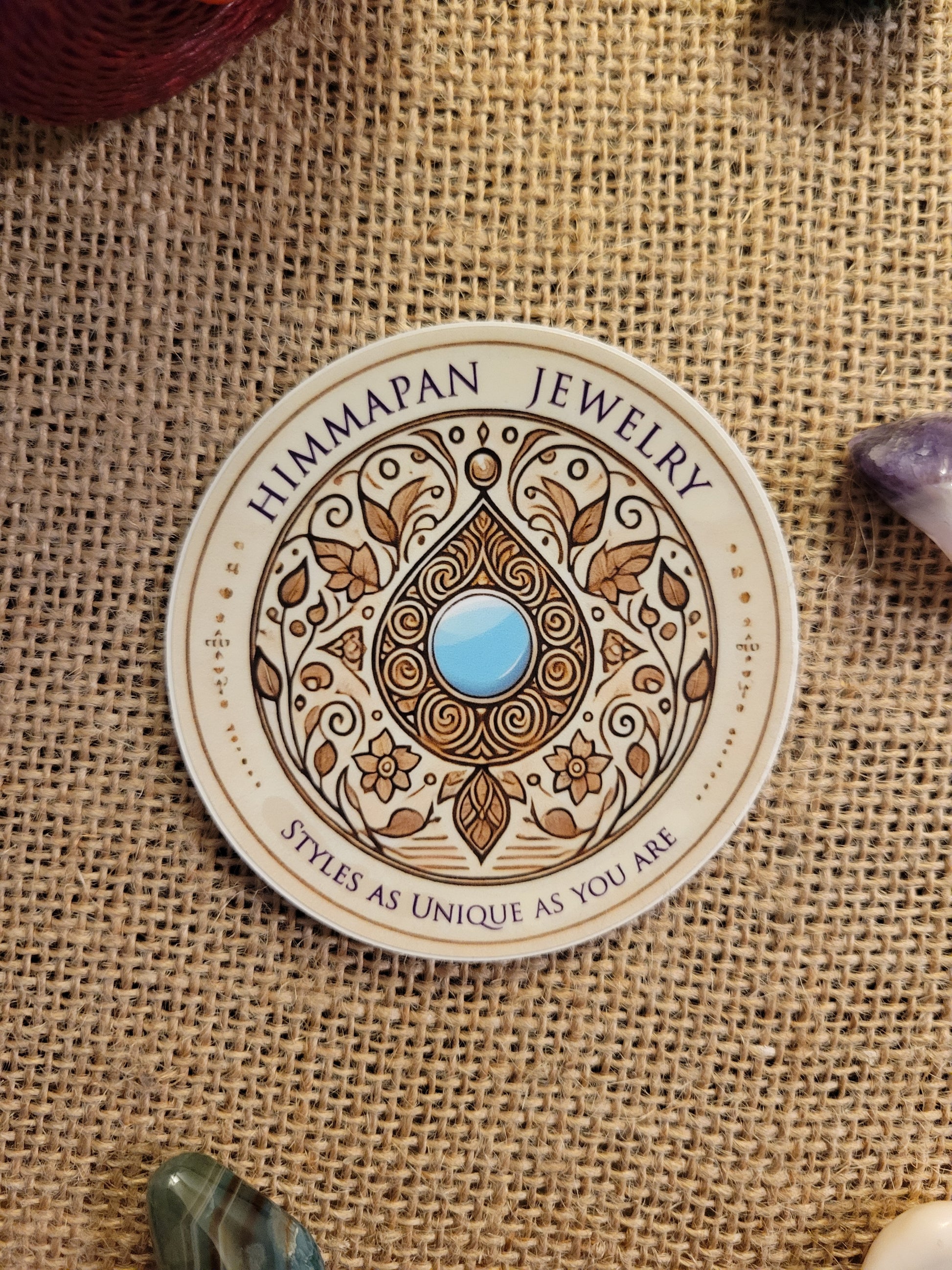 Himmapan Jewelry Logo Sticker – 3-inch round waterproof vinyl decal with floral design and blue gem.