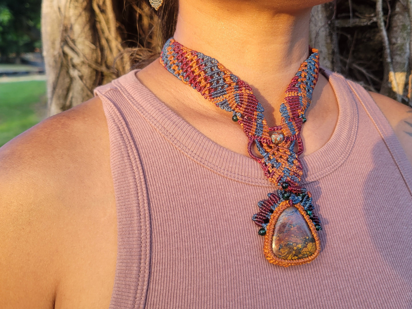 Agate Pendant – Colorful boho macramé necklace with floral accents worn by a model outdoors.