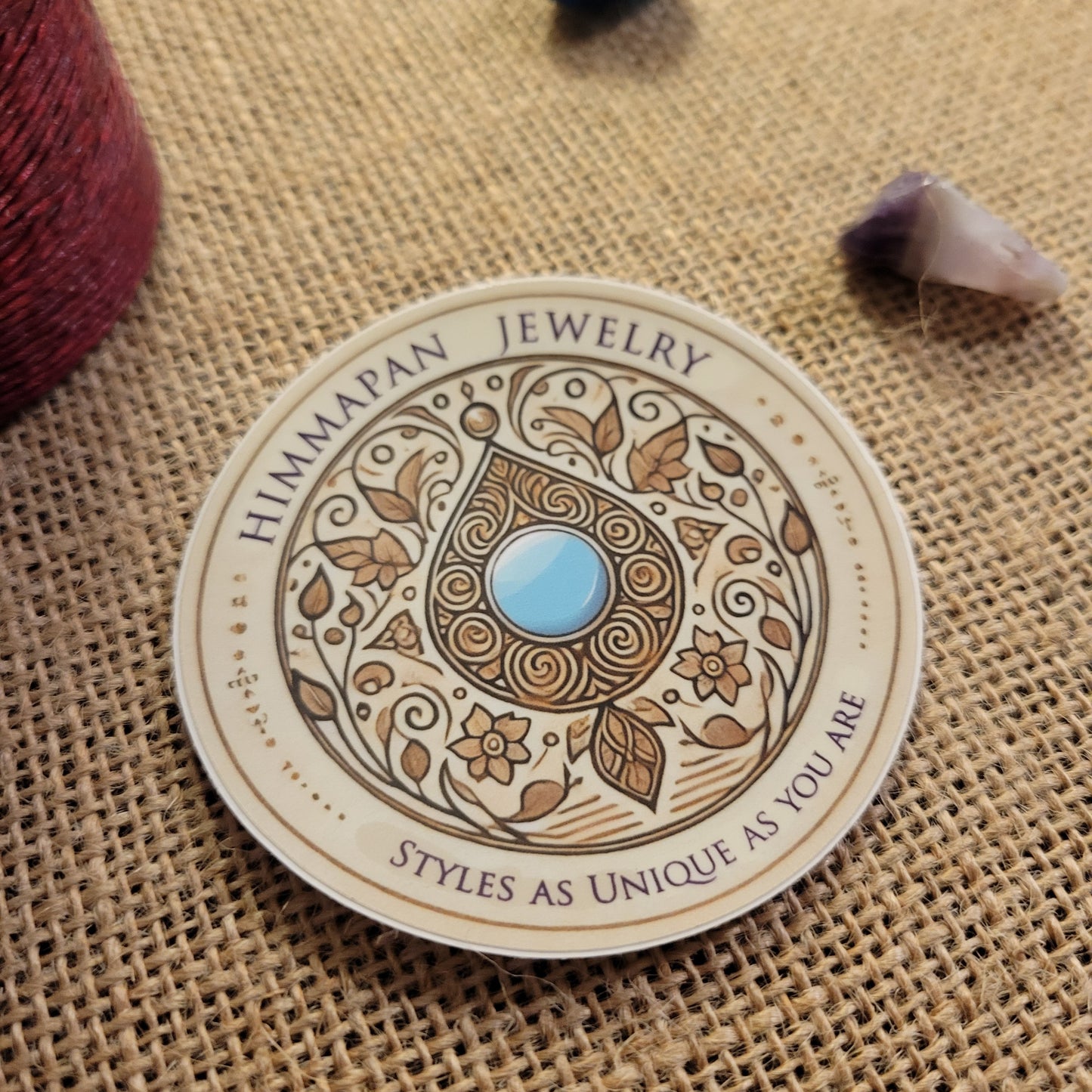 Himmapan Jewelry Logo Sticker – 3" round waterproof vinyl decal with unique design and blue gem in center.