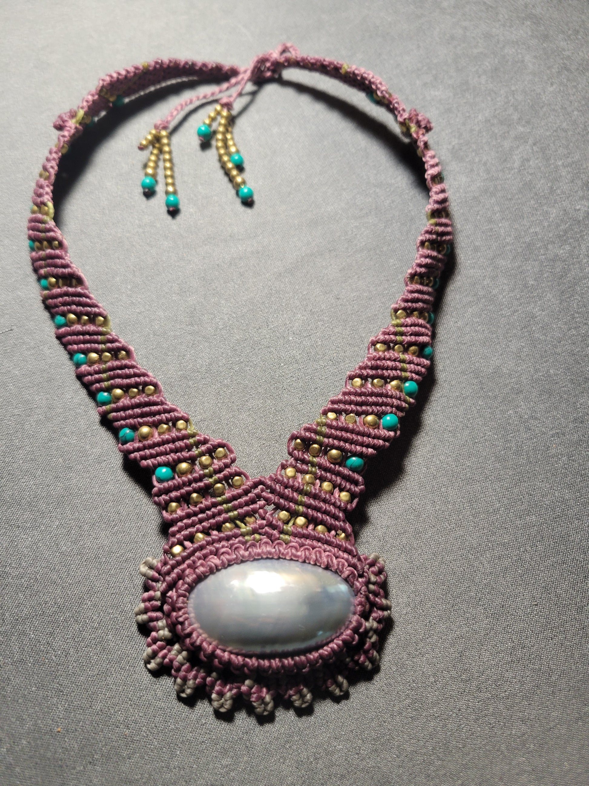 Macrame headband with a central stone on a gray background