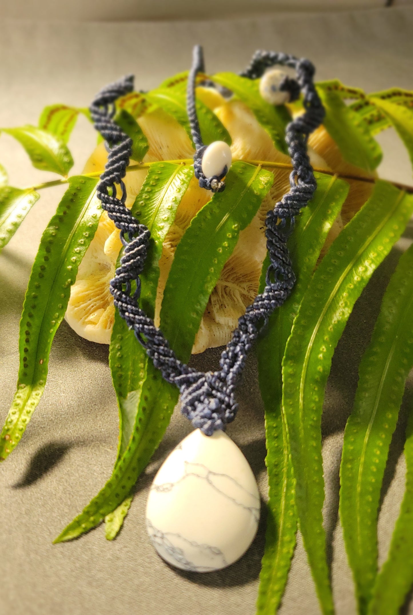 Howlite Pendant featuring a natural howlite stone and blue woven macramé necklace with zig zag pattern and white beads.