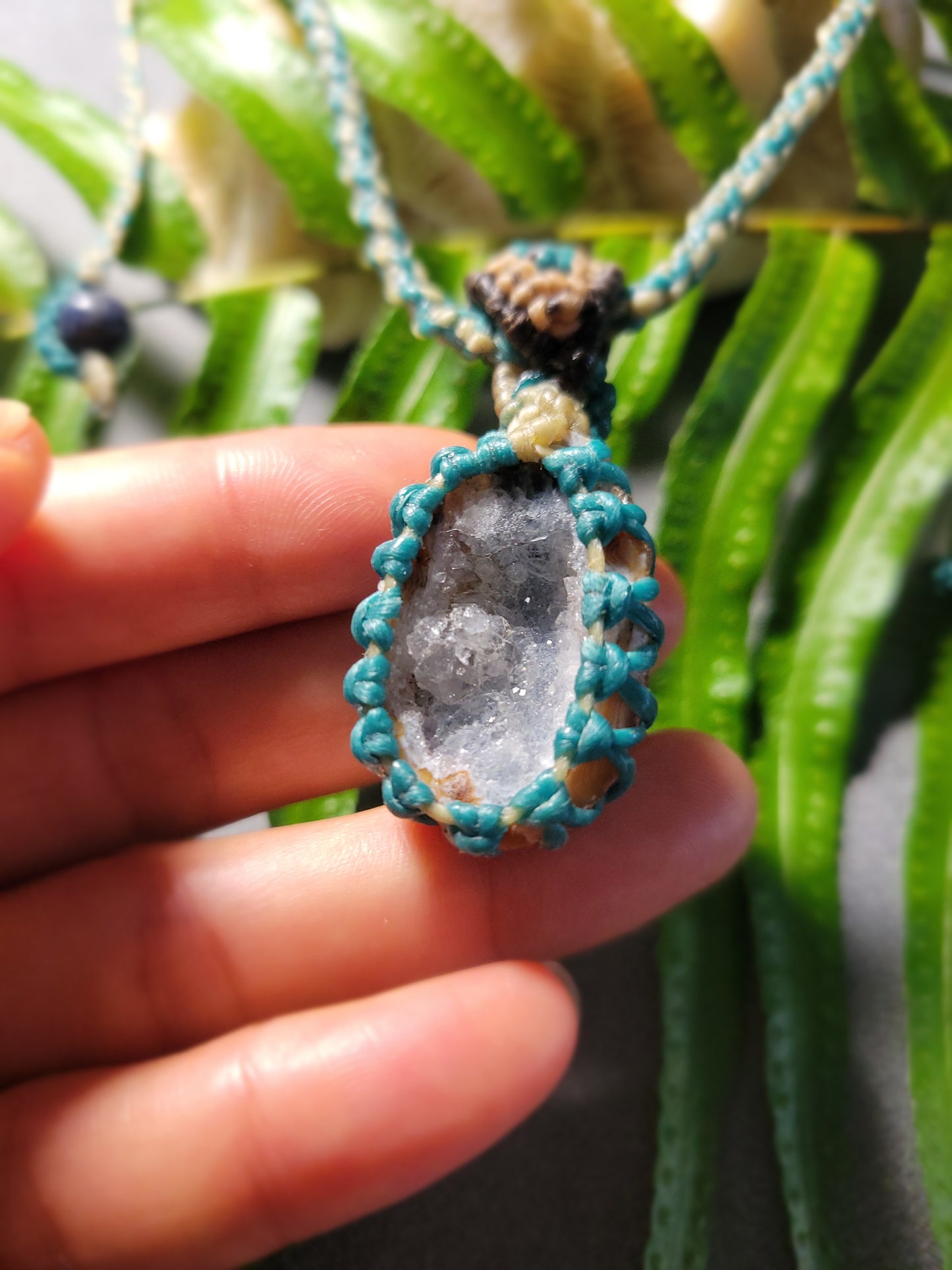Agate Geode Pendant – Purple Snow Druzy Spiral Boho Necklace held by hand with aqua cord.