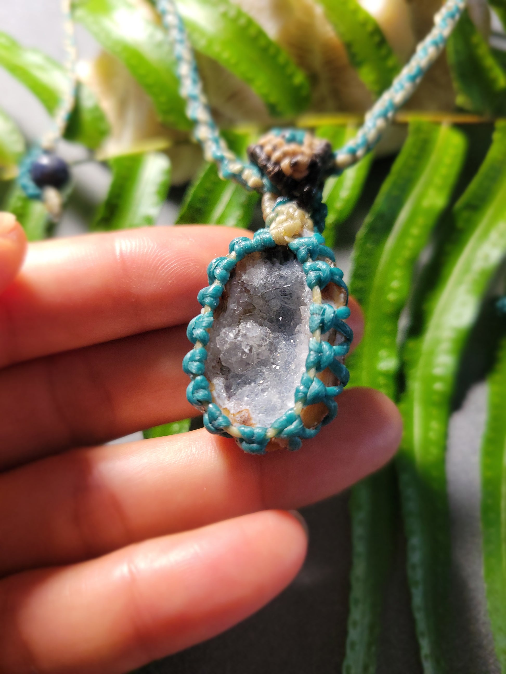 Agate Geode Pendant – Purple Snow Druzy Spiral Boho Necklace held by hand with aqua cord.