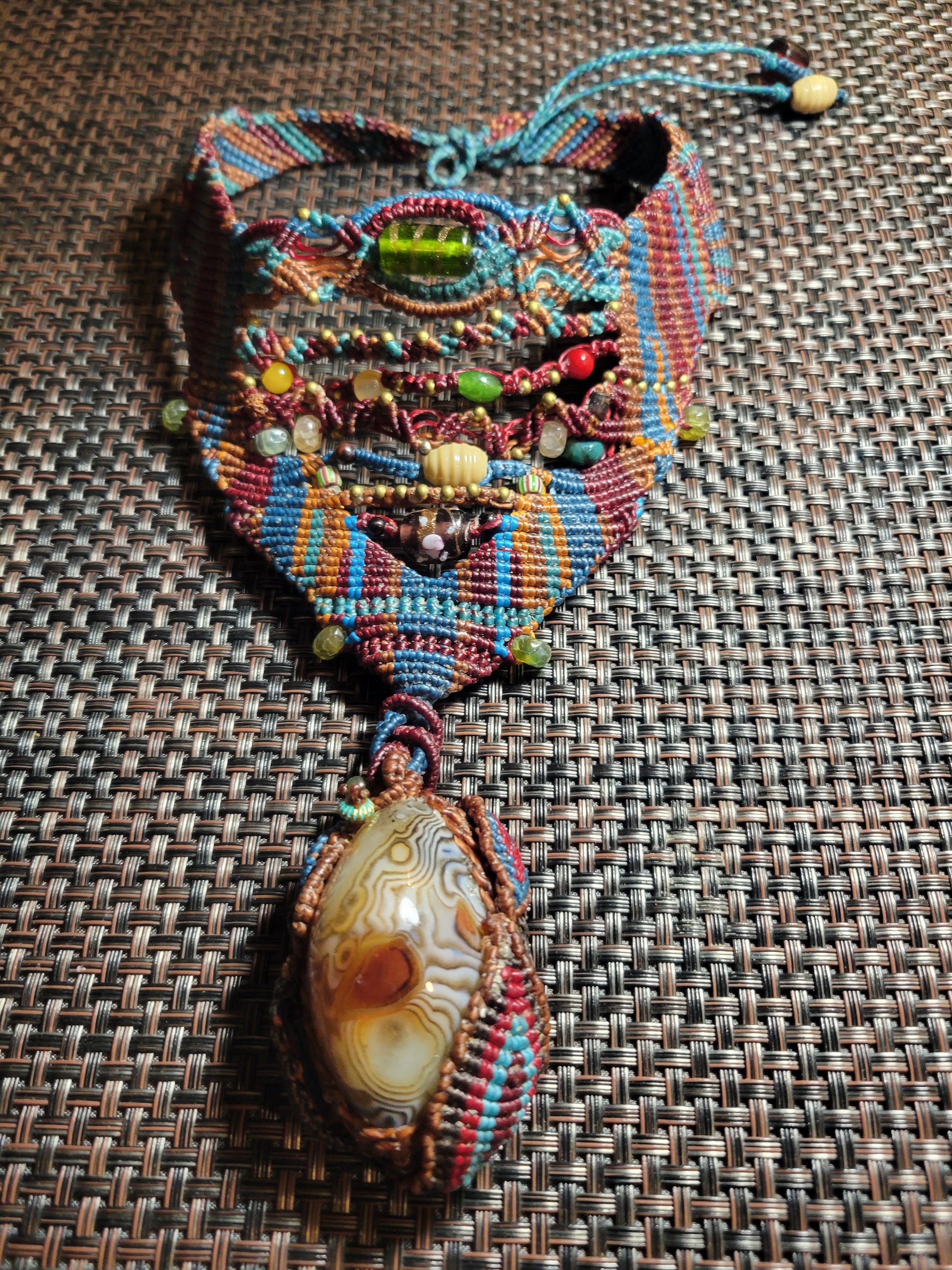 Botswana Agate Pendant featuring intricate micromacramé and natural stone beads in earthy tones.