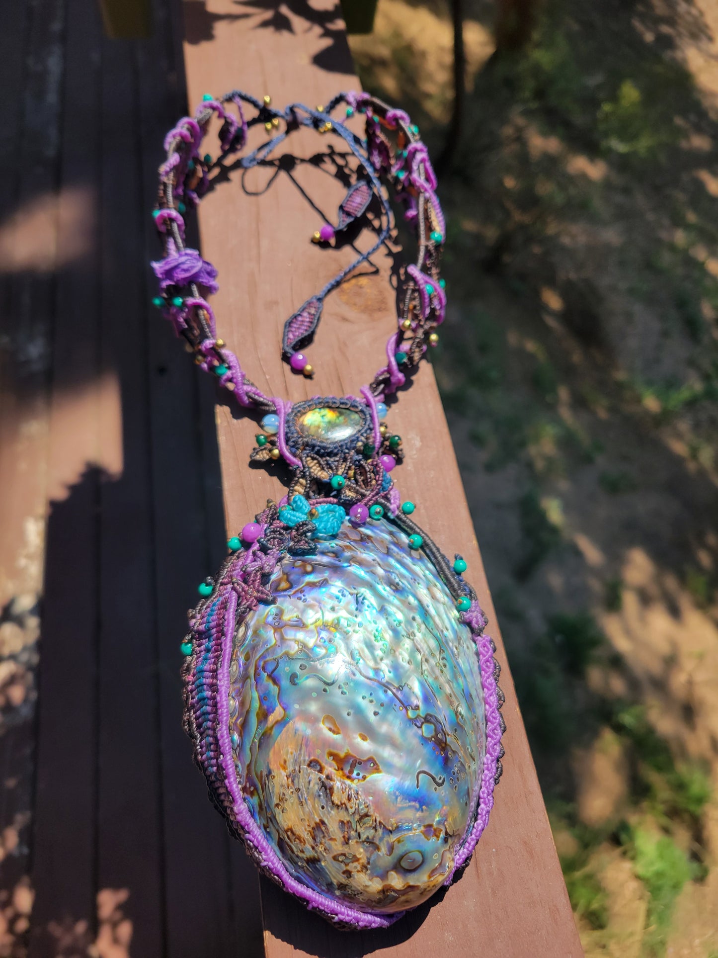 Ocean Necklace featuring large Australian abalone pendant with vibrant colors and intricate micromacramé design.